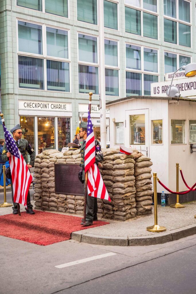 Due uomini vestiti da soldati presidiano Checkpoint Charlie