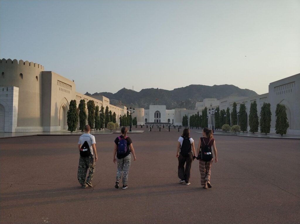 Persone di spalle passeggiano in città al tramonto in Oman