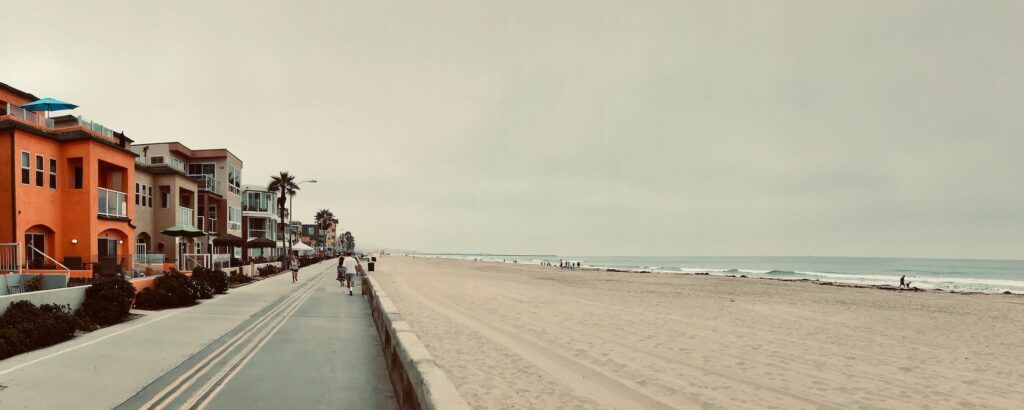 Delle persone camminano sul lungomare in una giornata nuvolosa