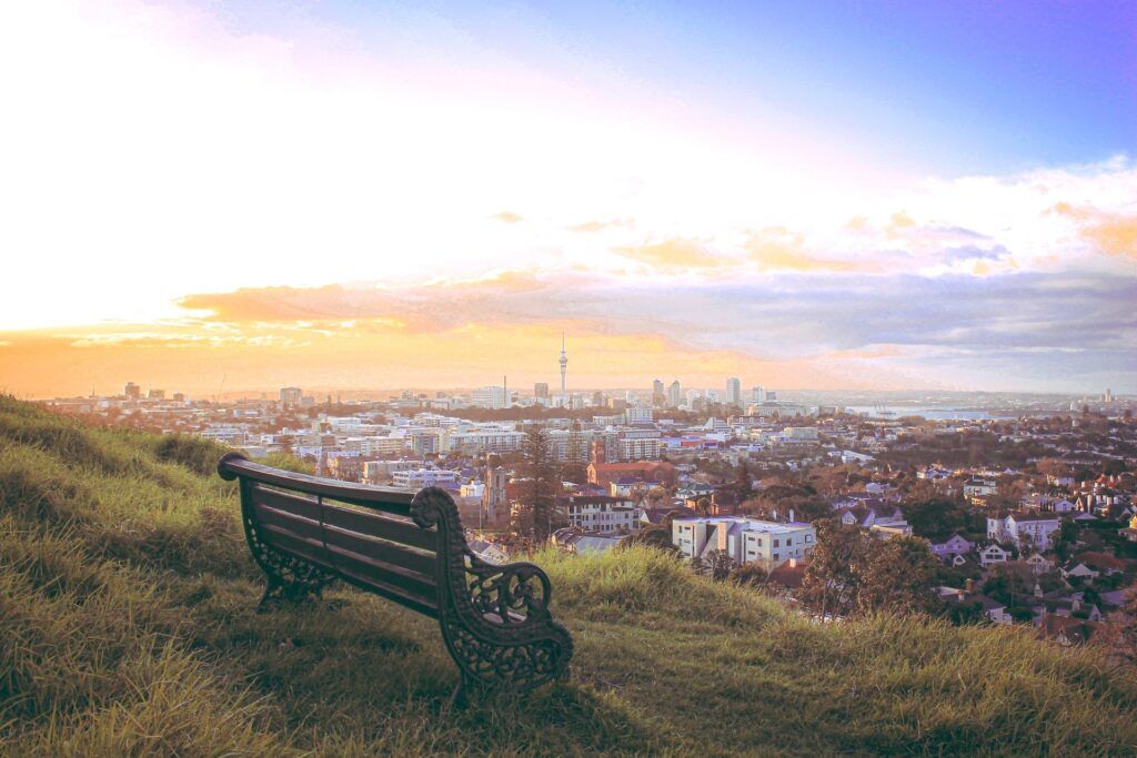 Una panchina su una collina con vista sullo skyline di Auckland in Nuova Zelanda