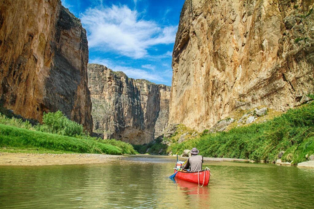 Un uomo su una canoa attraversa un corso d'acqua nel Big Bend National Park