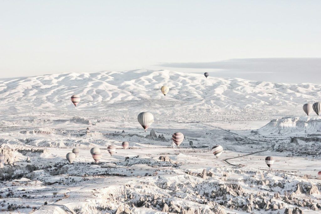 La Cappadocia innevata sorvolata dalle mongolfiere