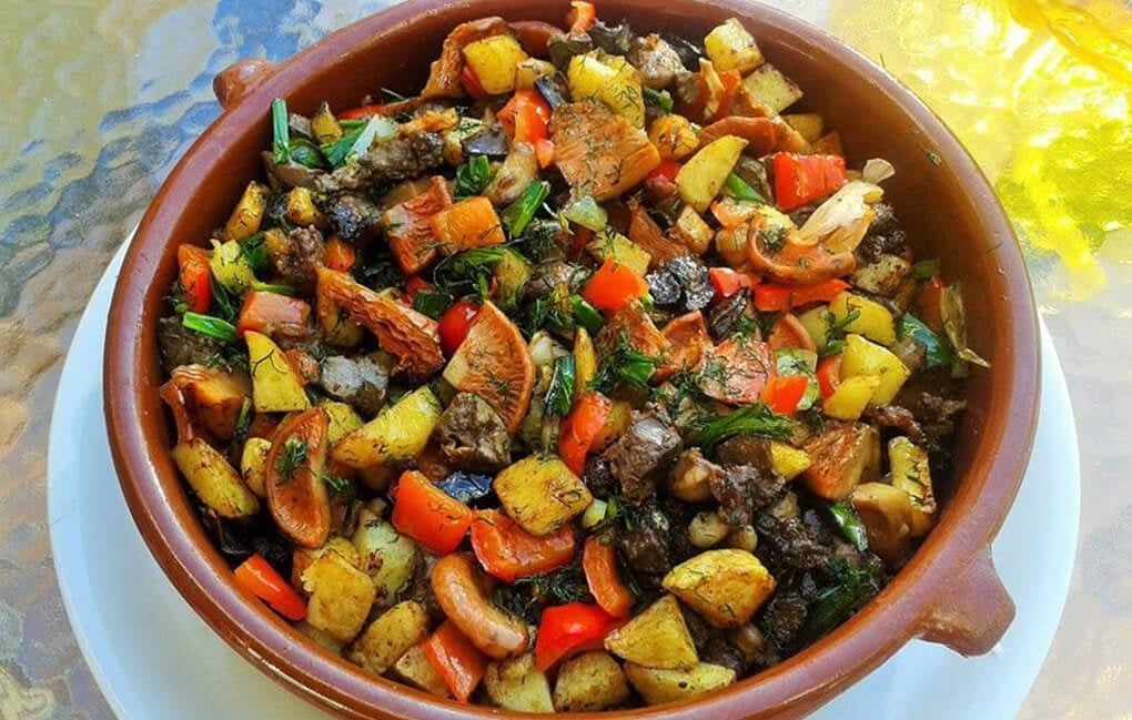 Frito Mallorquin, un piatto tradizionale con frattaglie di agnello o maiale, patate, peperoni, piselli e carciofi, il tutto fritto con olio d'oliva e spezie