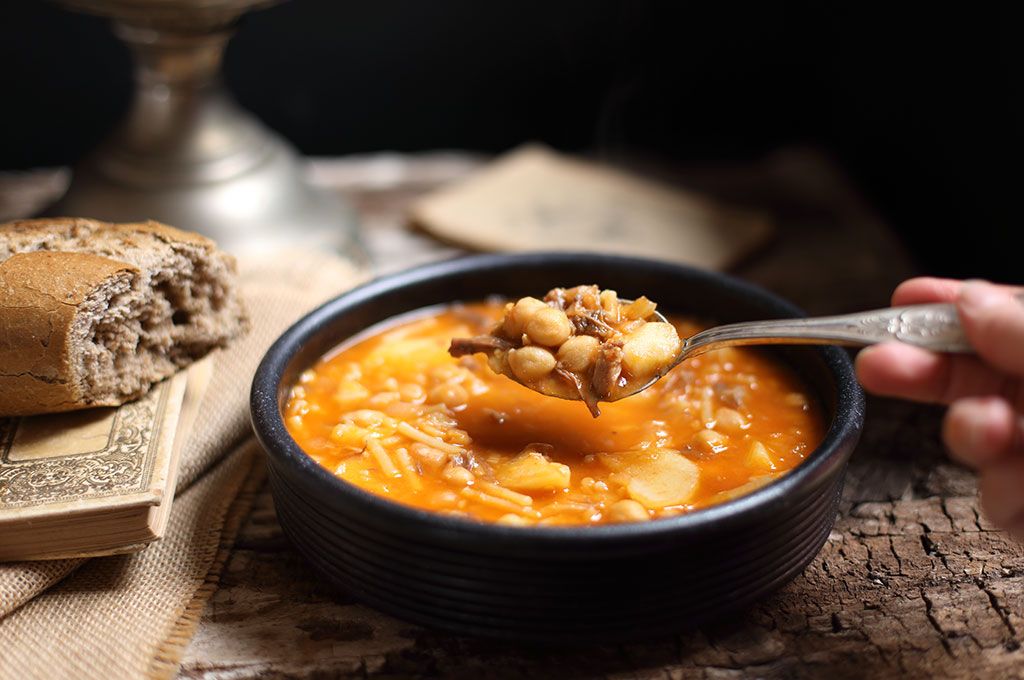 Un piatto di rancho canario, una zuppa tradizionale delle Isole Canarie, con ceci e verdure, accompagnata da pane