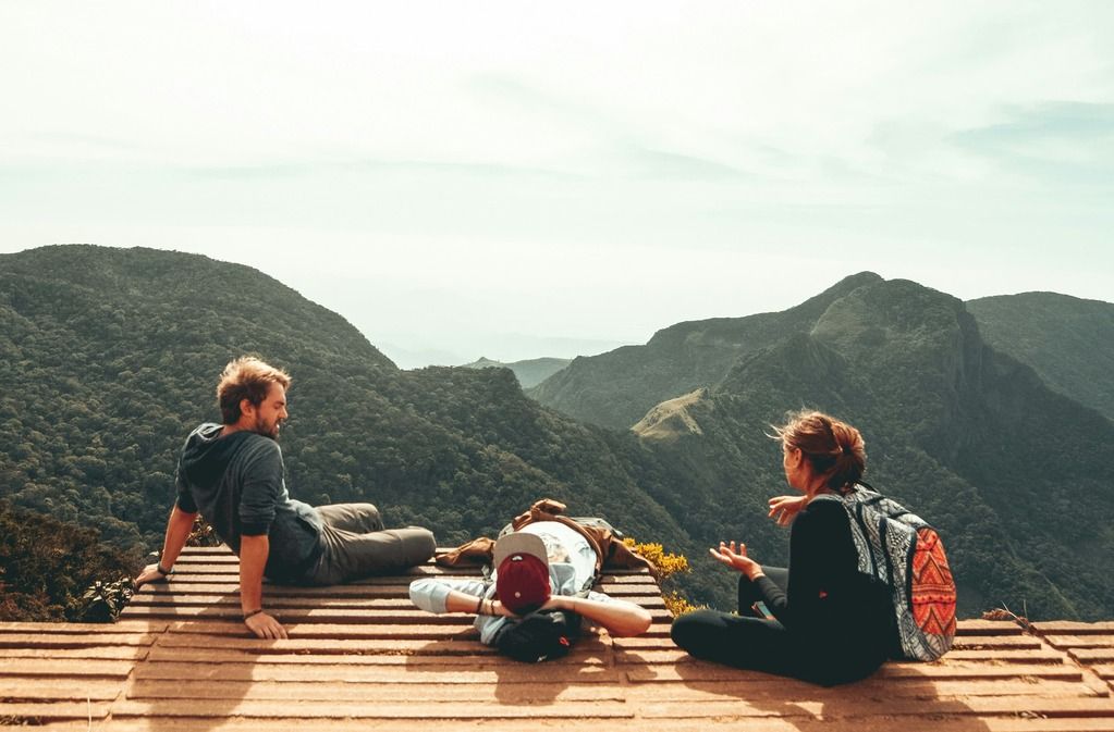 Gruppo di viaggiatori che si riposa su una terrazza panoramica tra le montagne, durante un'escursione nella natura.