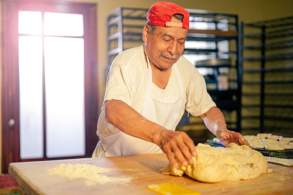 Panettiere colombiano al lavoro: tra farina, mani esperte e sorrisi sinceri, nasce il profumo autentico del pandebono e di altre bontà locali.