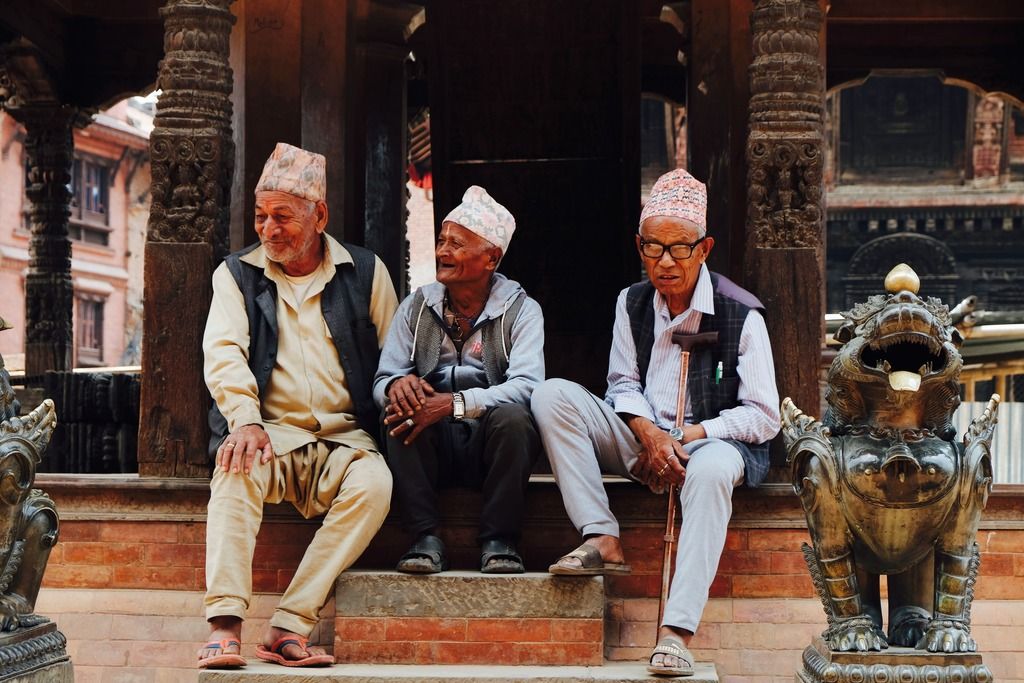 Anziani nepalesi seduti davanti a un tempio a Bhaktapur