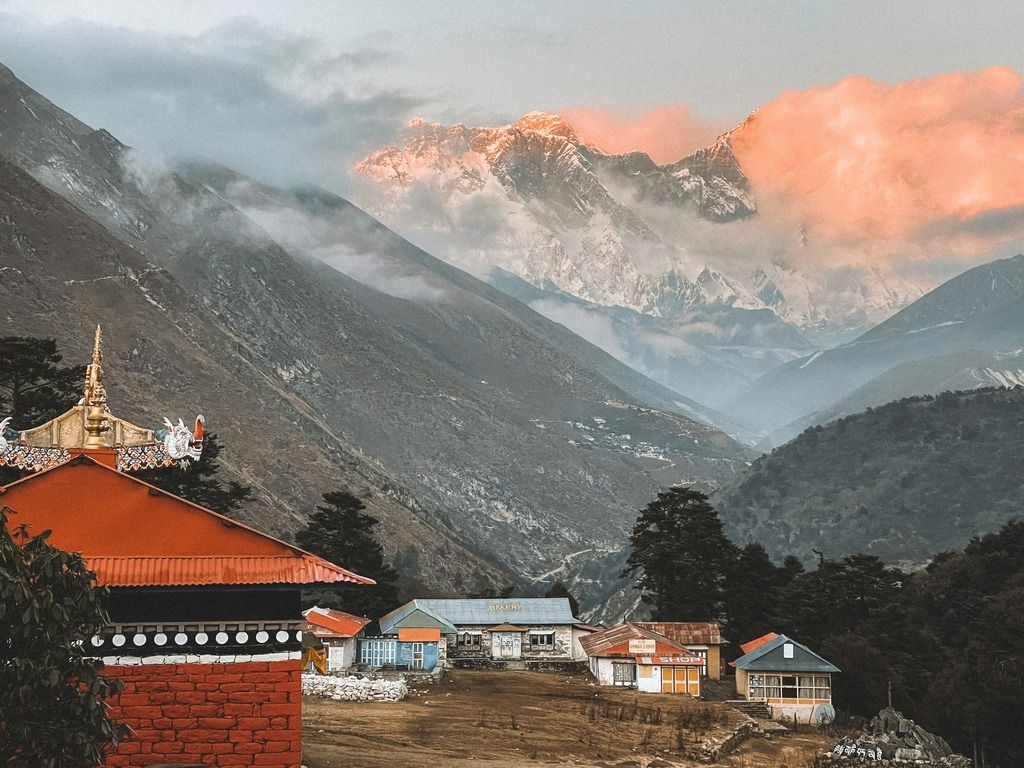 Villaggio himalayano con tempio buddhista all’alba e vette innevate sullo sfondo