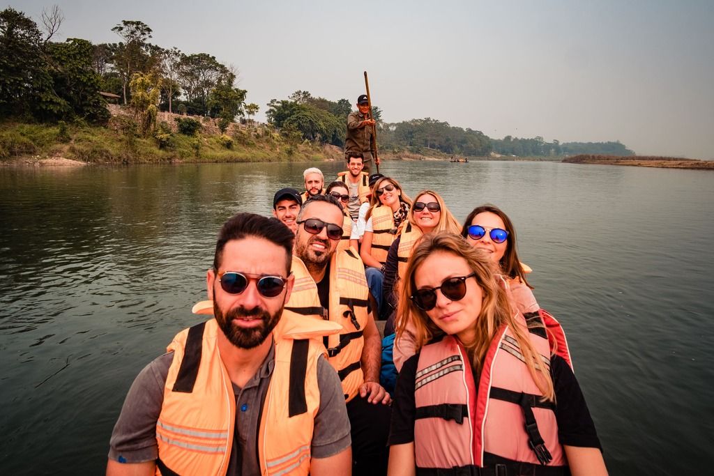 Viaggiatori in canoa nel Parco di Chitwan: tra fiume, natura selvaggia e avventura condivisa.