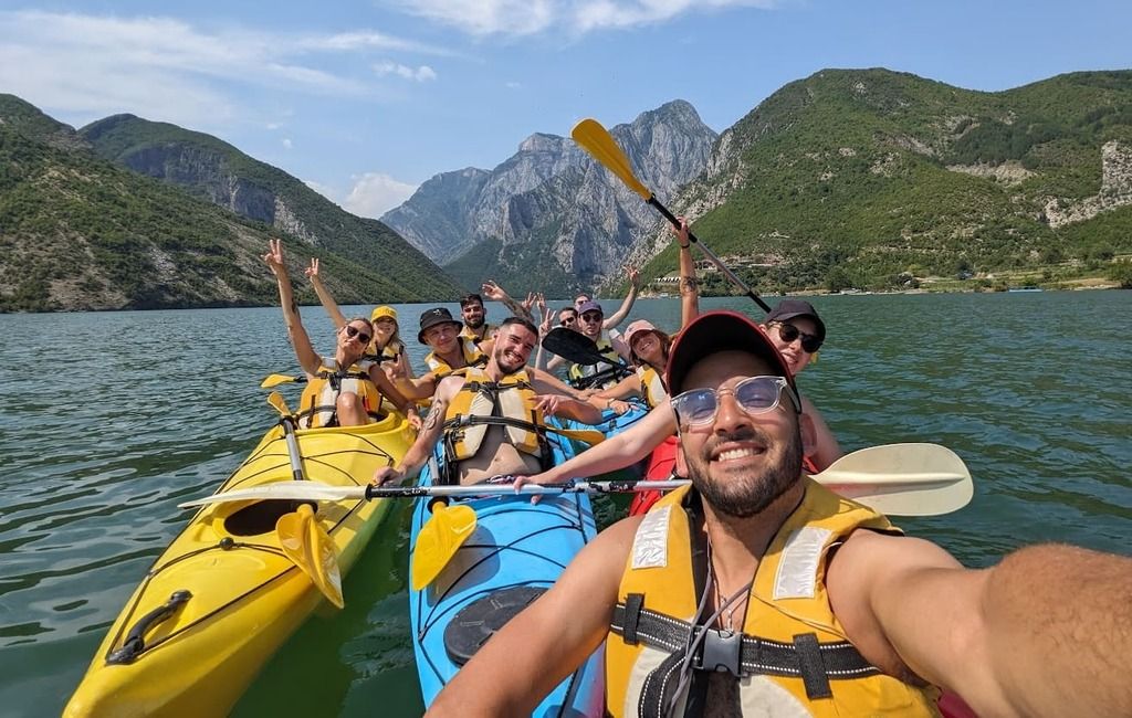 Gruppo WeRoad in canoa tra un paesaggio montano in Albania.