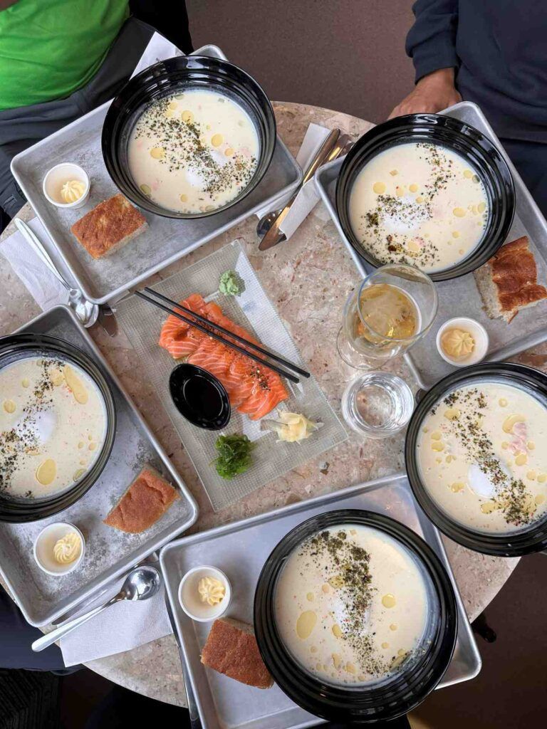 Una tavola imbandita con piatti di zuppe di pesce cremose.