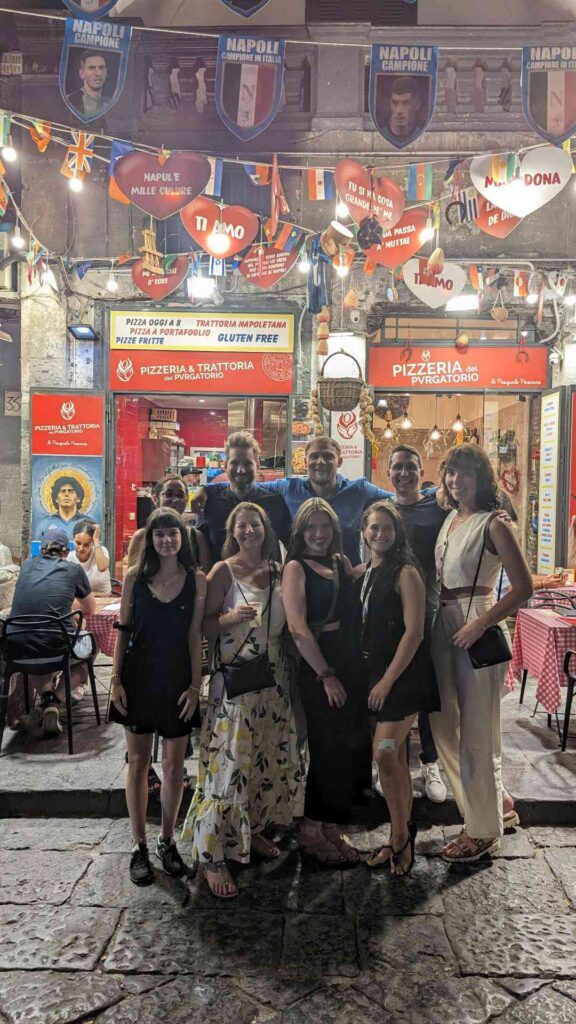 Gruppo WeRoad in posa davanti ad una pizzeria a Napoli.