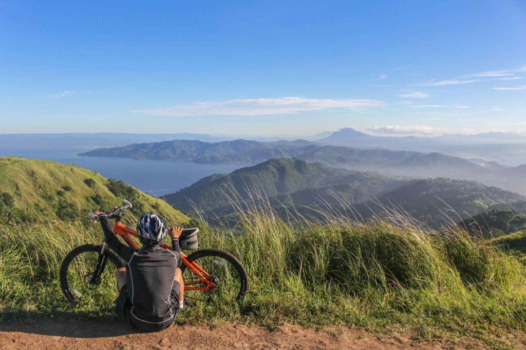 Ciclista si gode la vista in montagna a Ferragosto.