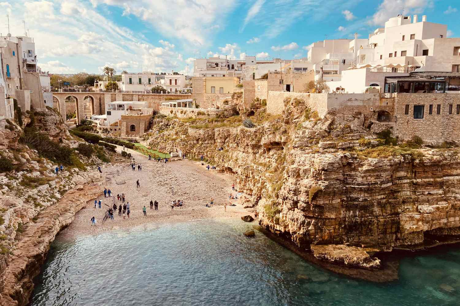 Vista aerea del borgo di Polignano a Mare con case bianche arroccate sulle scogliere e mare turchese in Puglia