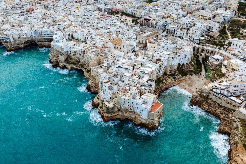 Vista dall'alto di una caletta con acque cristalline trasparenti e fondale roccioso tra le scogliere pugliesi
