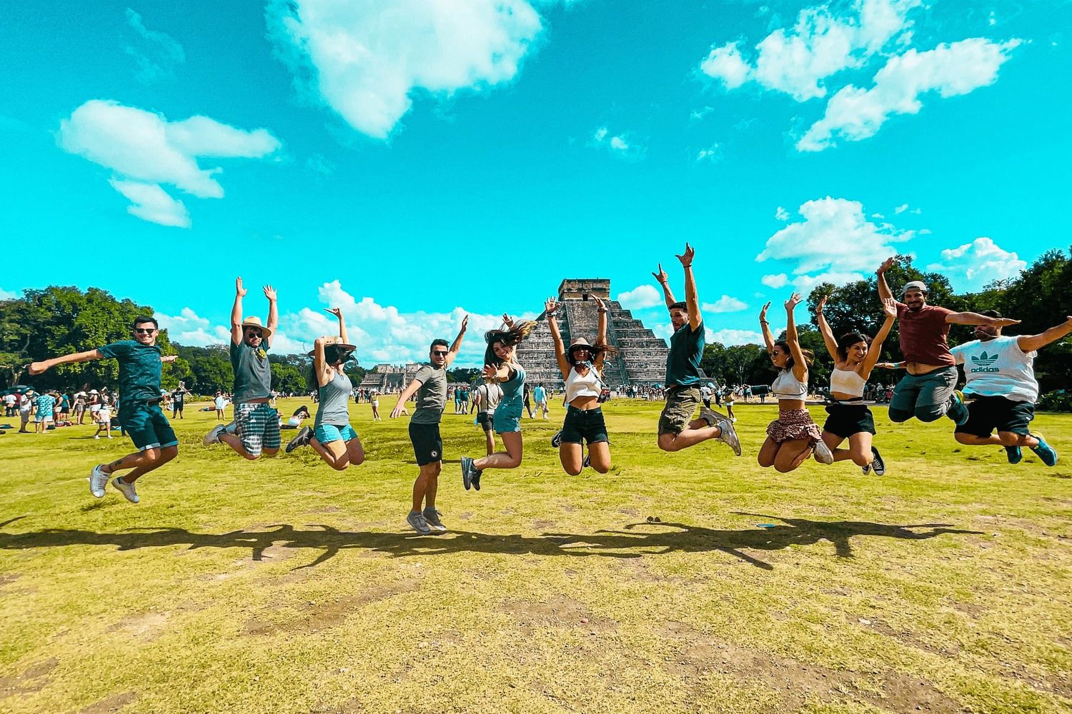 A WeRoad group jumping together in front of a Mayan pyramid