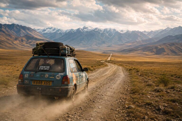 Auto carica di bagagli percorre una strada sterrata nella steppa dell'Asia Centrale con montagne innevate sullo sfondo