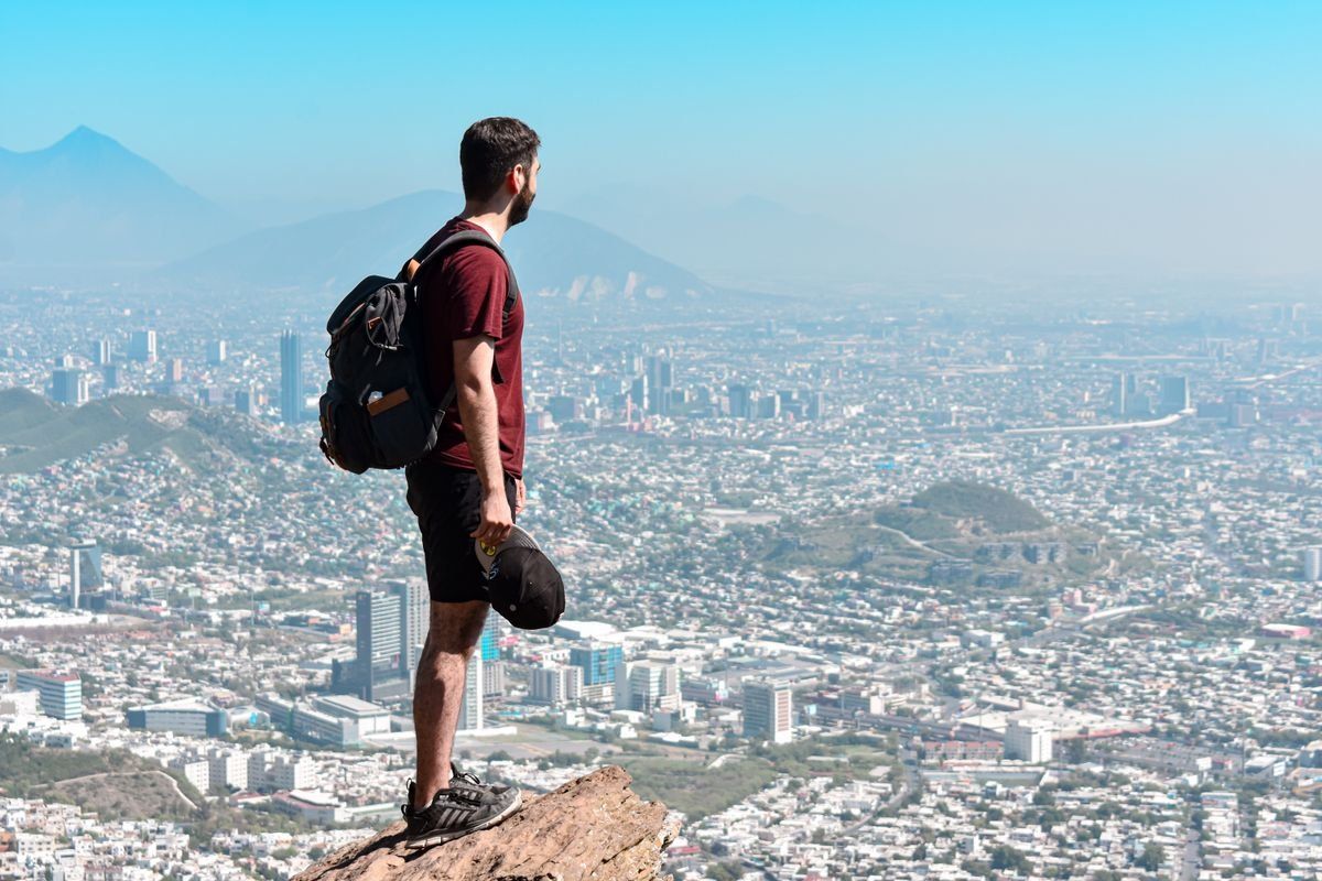 Ragazzo solo in viaggio ammira un panorama.