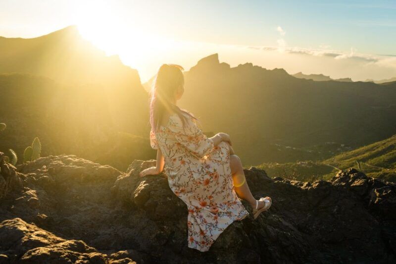 Ragazza sola in viaggio, ammira un alba.