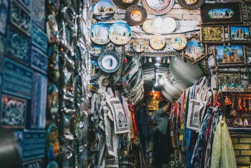Corridoio di un bazar coperto a Samarcanda con piatti in ceramica decorata e tessuti tradizionali in vendita