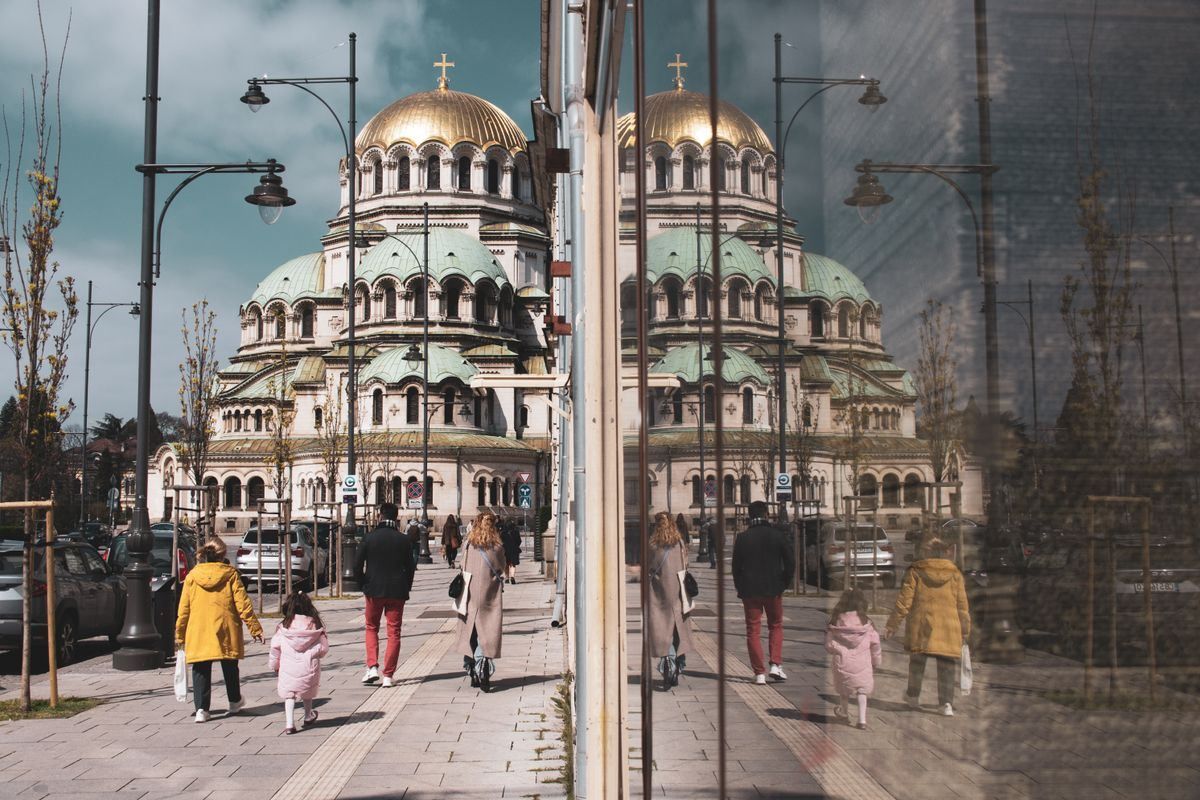 Cattedrale Aleksandr Nevskij riflessa in una vetrata lungo una strada con passanti