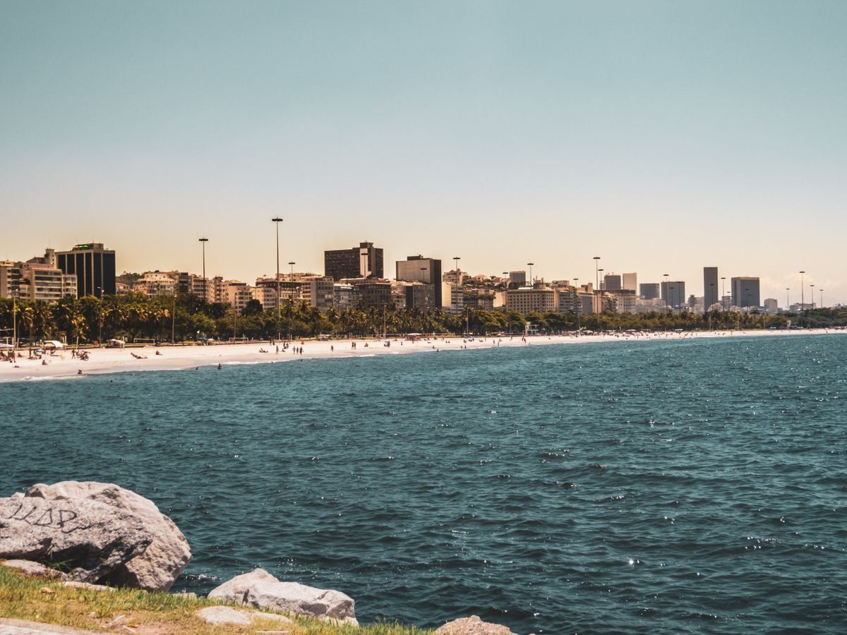 Litorale urbano con spiaggia, mare calmo e skyline di edifici sullo sfondo