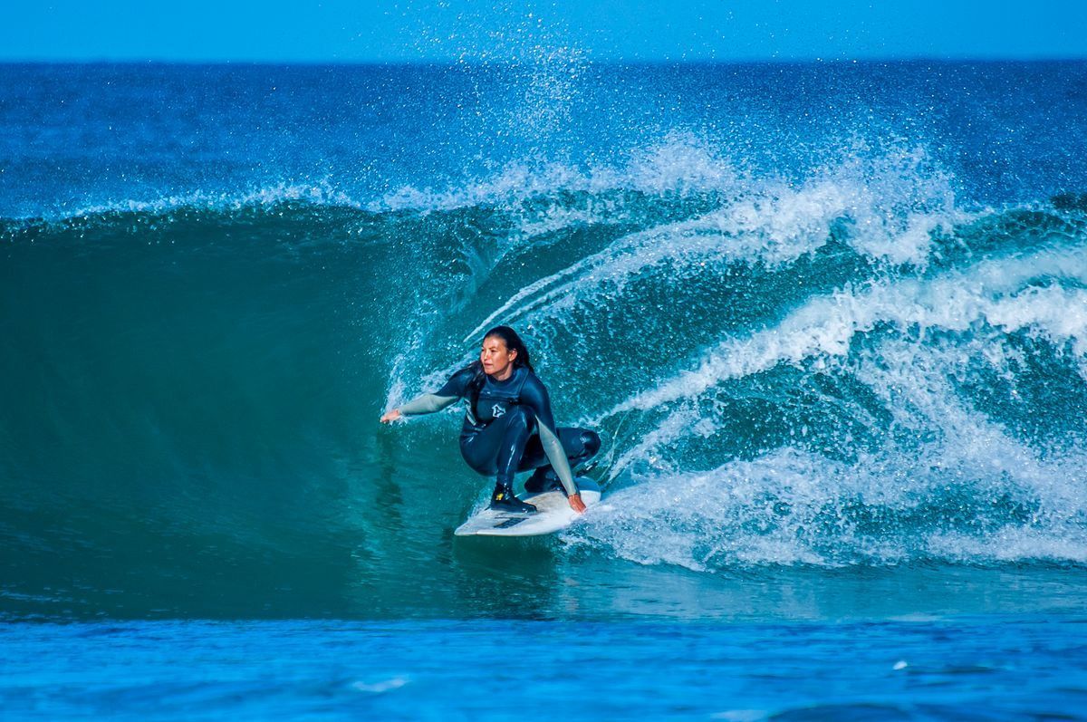 Surfista su un'onda grande mentre sfiora l'acqua con la mano