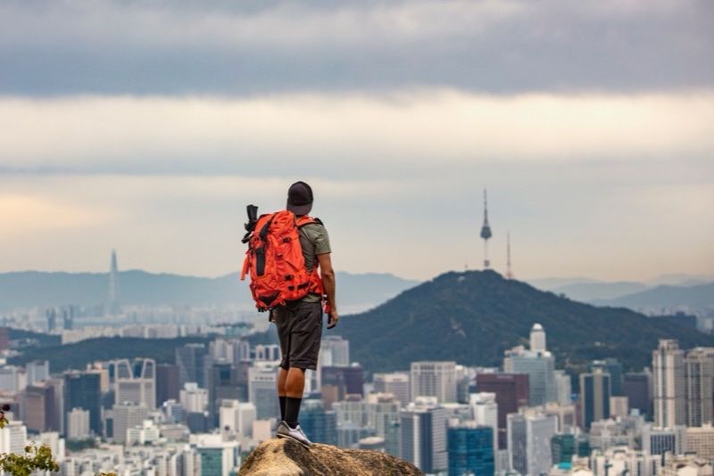 Escursionista con zaino davanti allo skyline della citta