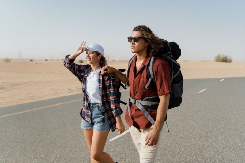 Coppia con zaini su strada nel deserto