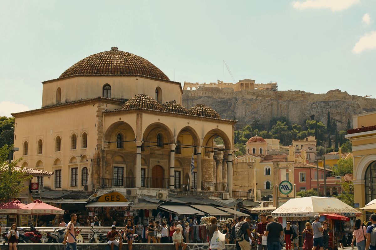 Piazza Monastiraki con folla, edificio con cupola e Acropoli sullo sfondo