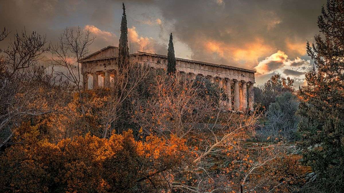 Tempio di Efesto tra alberi dai toni autunnali al tramonto ad Atene