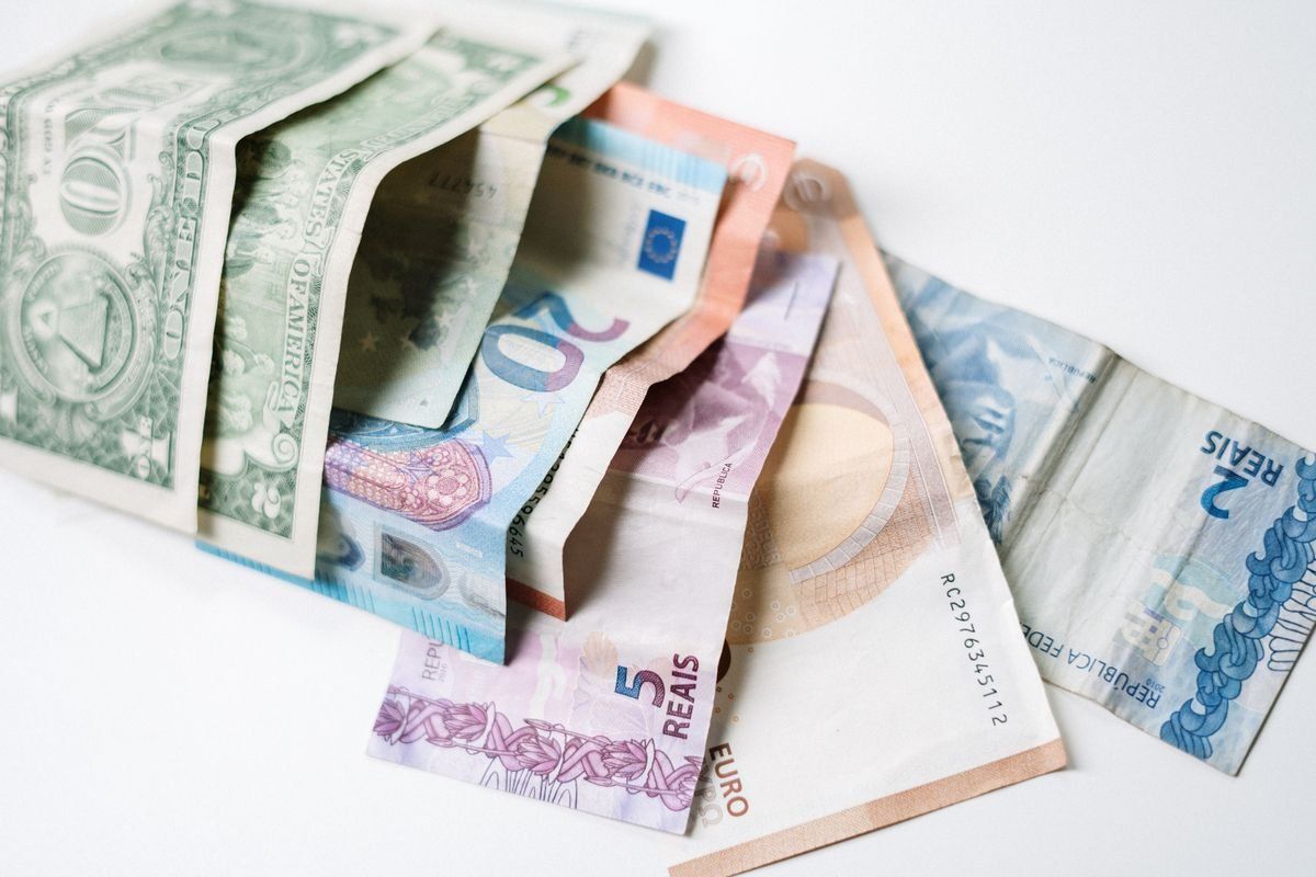 Banconote di diverse valute internazionali su sfondo bianco