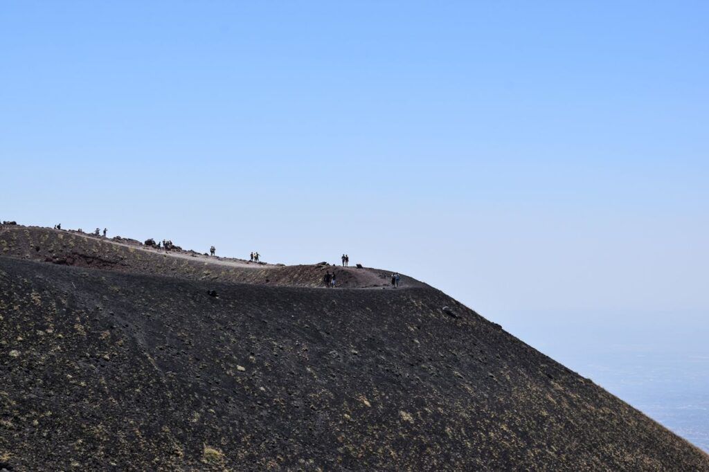 Escursionisti sul bordo di un cratere dell'Etna, in Sicilia
