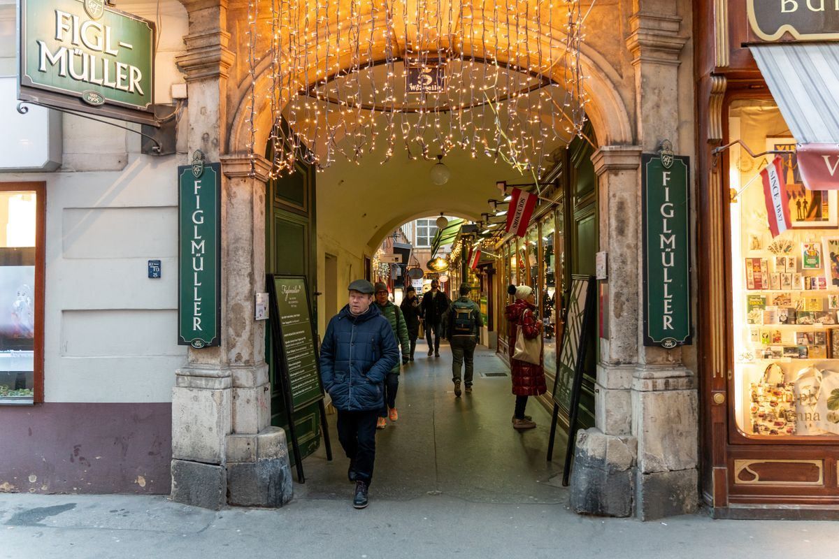 Ingresso del ristorante Figlmüller con luci natalizie in un passaggio coperto di Vienna