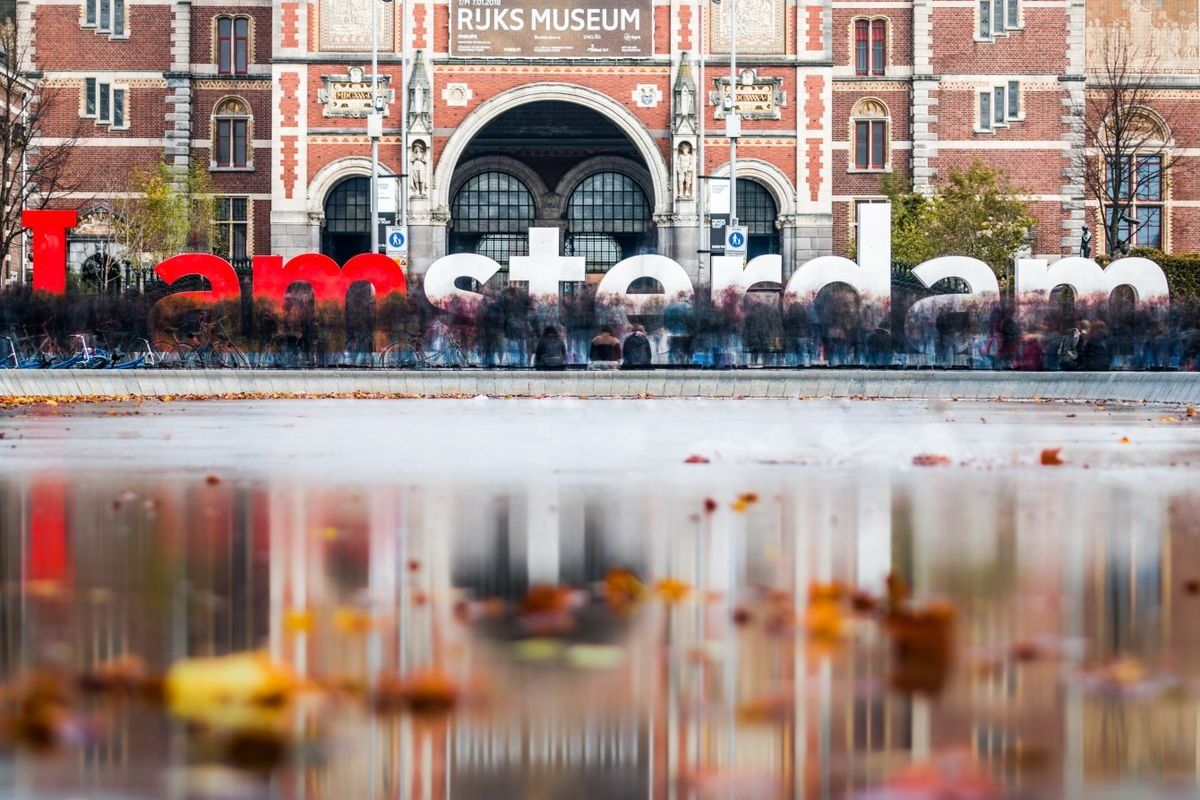 Scritta I amsterdam davanti al Rijksmuseum con riflessi sull’acqua e foglie autunnali