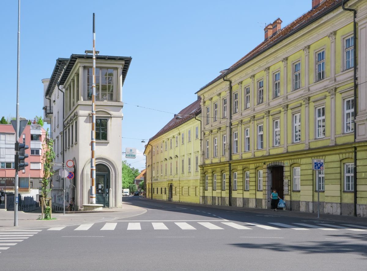 Strada tranquilla con edifici storici chiari e palazzo giallo lungo il marciapiede