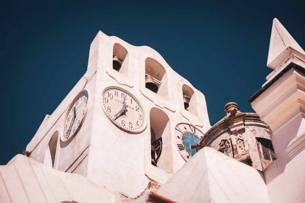 Torre dell'orologio bianca ad Anacapri sotto un cielo azzurro