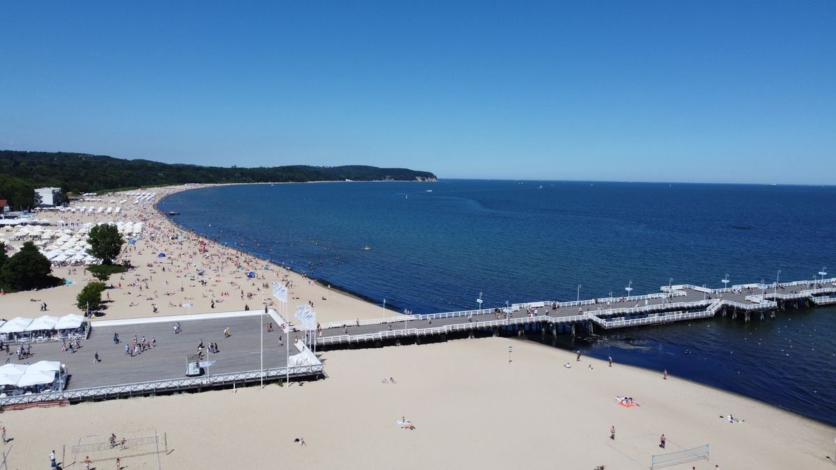 Vista dall'alto del molo di Sopot che si allunga sulla spiaggia e sul mare blu