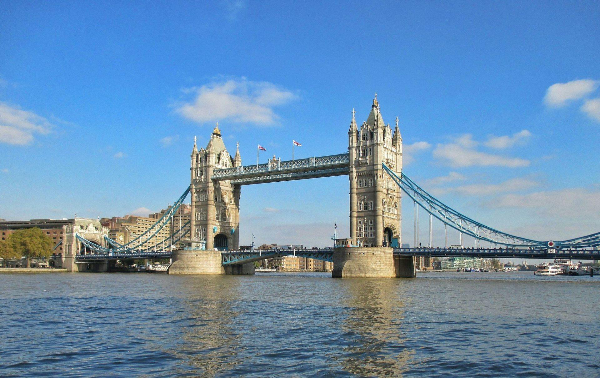 Un gran puente basculante y colgante con dos torres que cruza un río ancho bajo un cielo azul claro.