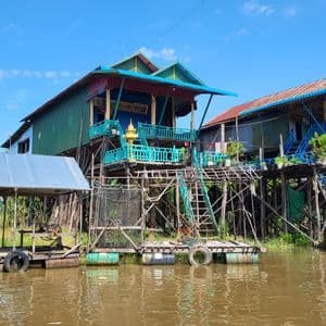 Casas coloridas sobre pilotes y plataformas flotantes en un pueblo construido sobre un río lodoso