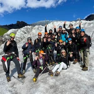 Un grupo de WeRoad posa en un glaciar, con cascos y arneses y empuñando piolets.