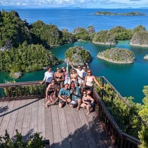 Un grupo de WeRoad posa para una foto en un mirador de madera, con vistas a una bahía tropical repleta de numerosas islas verdes y rocosas.