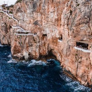 Des restaurants et des plateformes d'observation aménagés à même la paroi d'une grande falaise, surplombant l'océan.