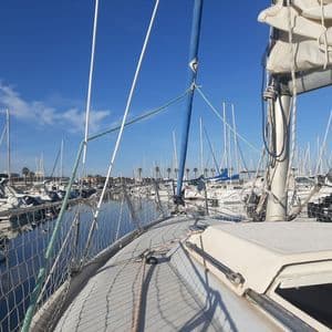 Vue depuis le pont d'un voilier amarré dans une marina remplie d'autres navires par une journée ensoleillée.