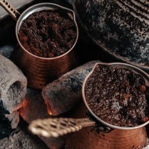 Due tradizionali bricchi di rame con caffè in lenta infusione su braci ardenti.