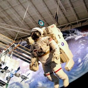 A model of an astronaut in a NASA spacesuit and the International Space Station suspended inside an exhibit hall.