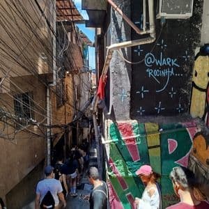 Un viaje en grupo de WeRoad baja escaleras en un estrecho callejón urbano con paredes cubiertas de grafitis y cables eléctricos enredados.