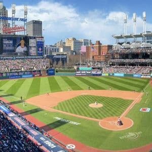 Un'ampia vista di una partita di baseball in uno stadio affollato con lo skyline della città visibile dietro il campo esterno.