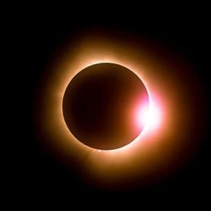 Der Mond erzeugt eine totale Sonnenfinsternis, wobei die Korona der Sonne und der Diamantring-Effekt vor einem schwarzen Himmel sichtbar sind.