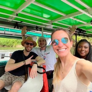 Un grupo WeRoad de cuatro personas sonriendo para una selfie en un barco cubierto durante una excursión fluvial.